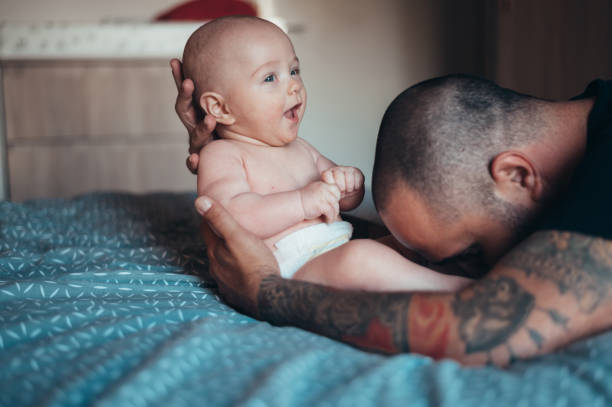 istock Tattooed bearded father playing with his son 1322367875
