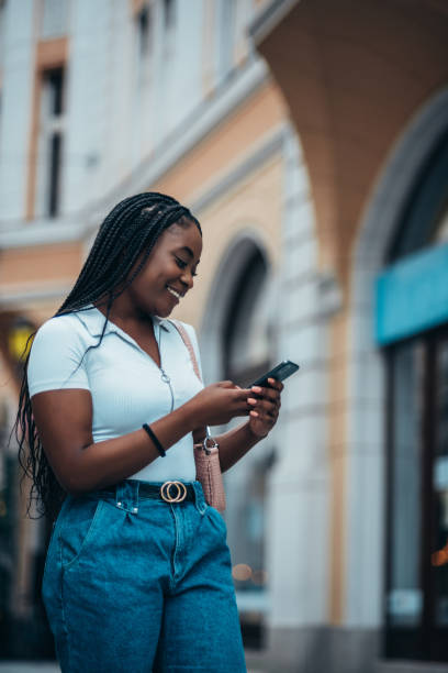 istock Cheerful african american woman using smartphone 1322367881