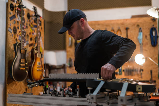 istock Black electrical guitar in repair service shop with a guitar luthier 1322367912