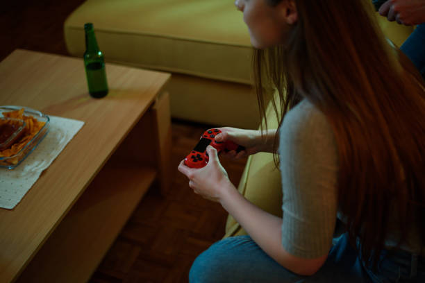 istock Young woman playing video games with a console at home 1322367920
