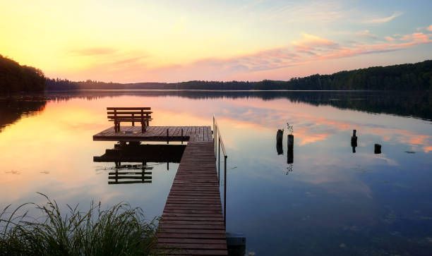 istock Bench on a wooden pier at sunset. 1322368599