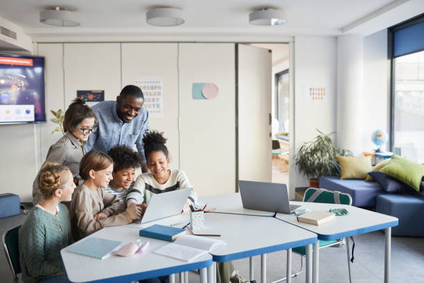 istock Group of Kids Looking at Computer Screen in School 1322369792
