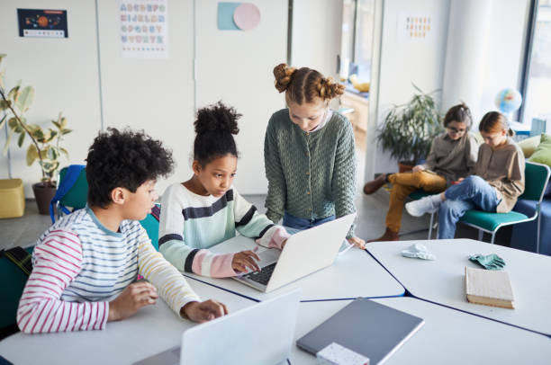 Group of Kids in Modern School High angle view at diverse group of children working together at desk in classroom at modern school, copy space 12 13 years stock pictures, royalty-free photos & images