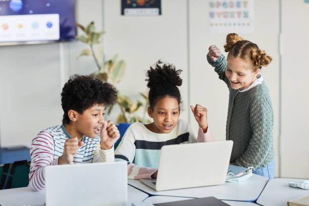 istock Excited Children Looking at Laptop Screen 1322369850
