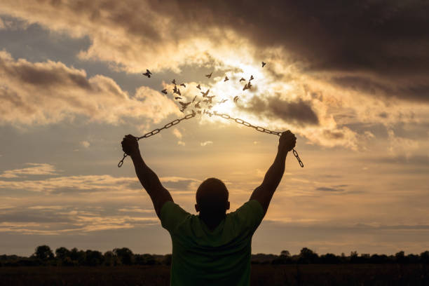 istock Man raised his hands and broke the chains that turned into birds. 1322371846