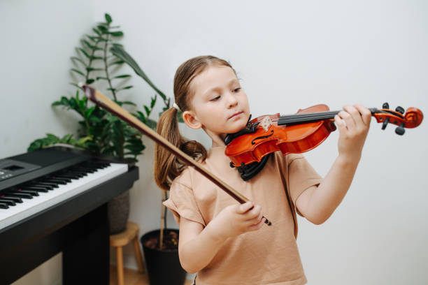 istock Cute little girl learning to play violin, assuming the posture 1322376015
