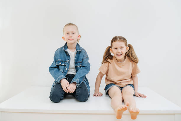 istock Little siblings sitting on a table, posing for a photo. 1322376034