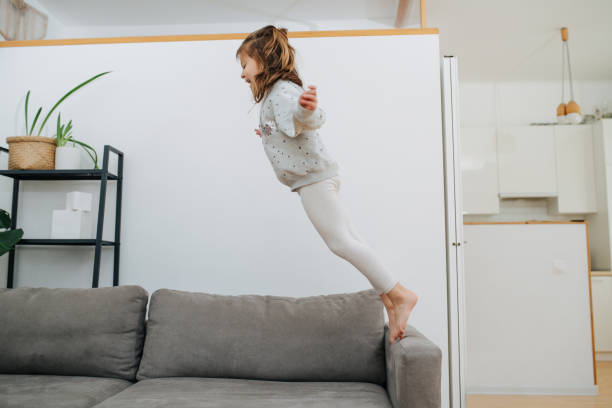 istock Adventurous little girl falling on a couch with her body flat. no one's watching 1322376037