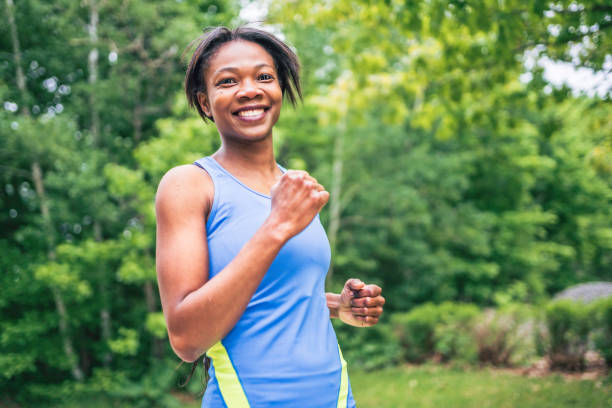 istock Woman runner in action outside in tree background 1322377061