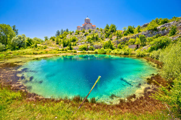 istock Cetina river source water hole and Orthodox church on the hill view 1322377812