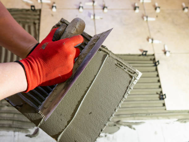 istock Applying thinset mortar on a tile. Apply the adhesive, closeup. 1322380495