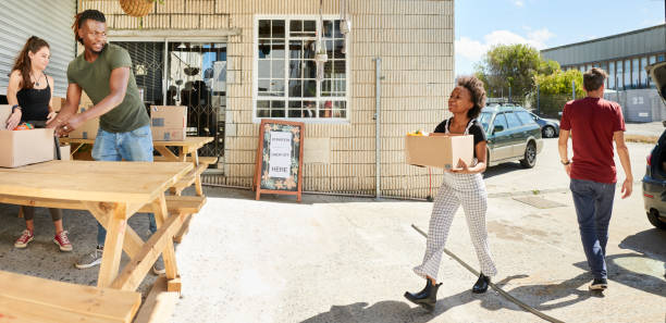 diverse young volunteers accepting donations at a community center - youth organization imagens e fotografias de stock