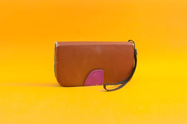 istock Old used brown phone case isolated on orange background 1322382204