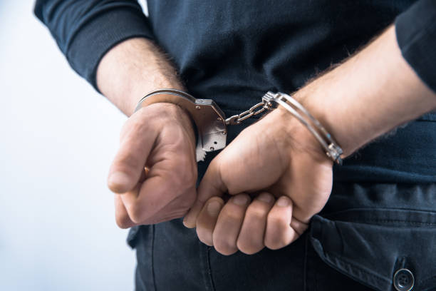 istock man hand handcuffs in back 1322382227