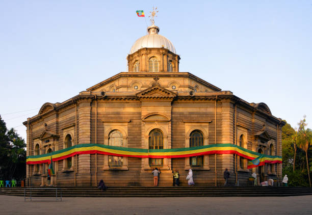 Saint George's Cathedral - built by European POWs for emperor Menelik II - Addis Ababa, Ethiopia Addis Ababa, Ethiopia: Saint George's Cathedral wrapped in the colors of the Ethiopain flag - Italian neoclassical style octagonal building with silver dome - built by emperor Menelik II in 1896 to celebrate the victory in the battle of Adwa against the Italians - the church was designed and built by Italian POWs, architect Sebastiano Castagna - Ethiopian flag and Ethiopian Orthodox Tewahedo Church cross with stylized ostrich eggs - Empress Zewditu was crowned at this Cathedral in 1917, and Emperor Haile Selassie was crowned there in 1930, and it became a pilgrimage destination for Rastafarians - Churchill Avenue, Arada district - Kiddus-Giyorgis / ገነተ ጽጌ መናገሻ ቅዱስ ግዮርጊስ. ethiopia city stock pictures, royalty-free photos & images