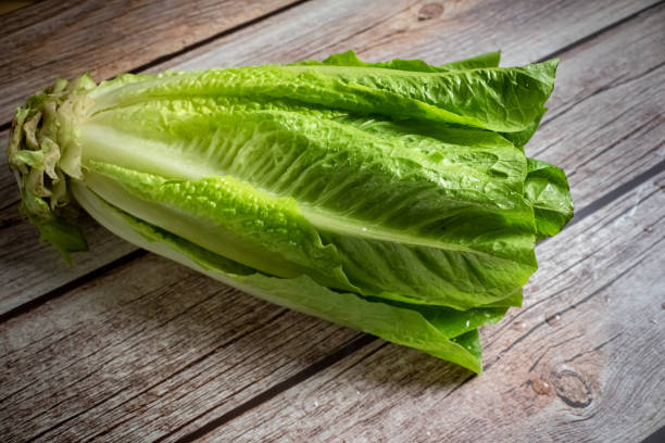istock Raw cos lettuce on wooden background 1322390745