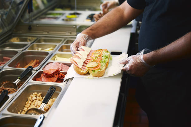 preparing sandwich in the fast food restaurant. cook's hands making the kitchen of restaurant submarine sandwich photos stock pictures, royalty-free photos & images