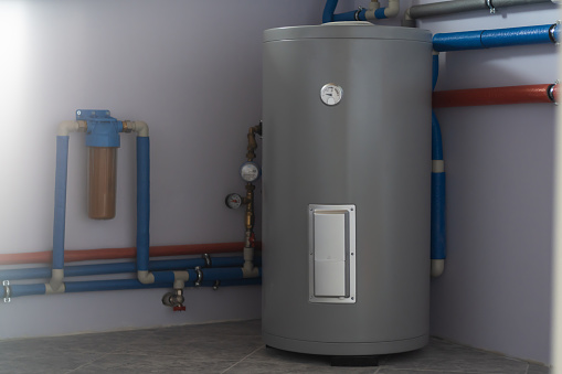 Tanque para calefacción indirecta de caldera, filtro de flujo para limpieza, tuberías de caldera y medidores en sala de calderas de casa privada photo