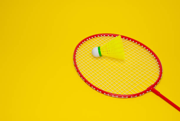 istock Badminton shuttle and racket isolated on yellow background 1322413226