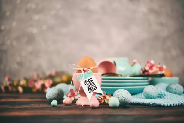 Easter table setting with eggs and dishes and Easter Blessings message on an eggcup