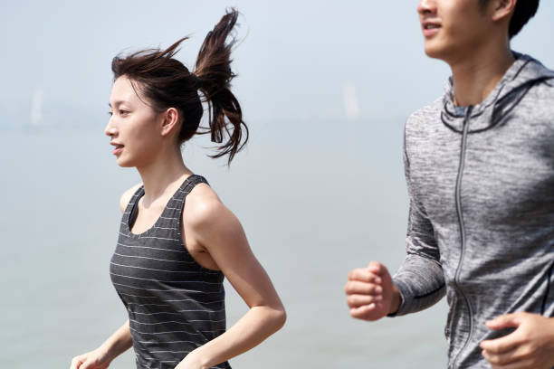 istock young asian couple running on beach 1322417678