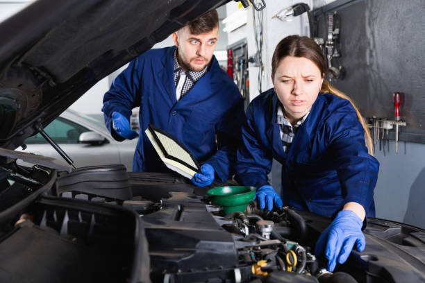 istock Two masters are replacing the oil in the car in workshop. 1322418505