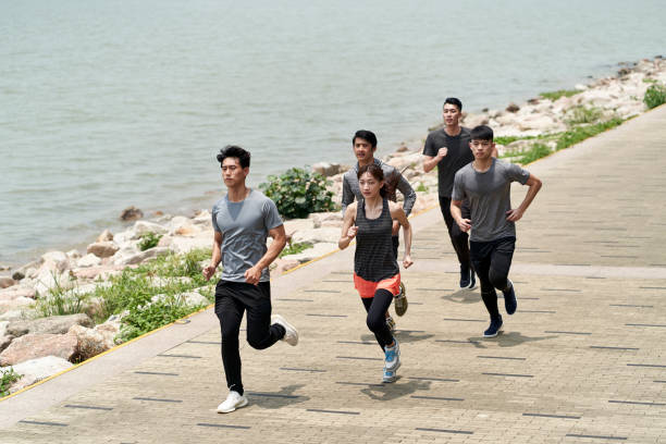 istock group of young asian adults running on beach 1322418543