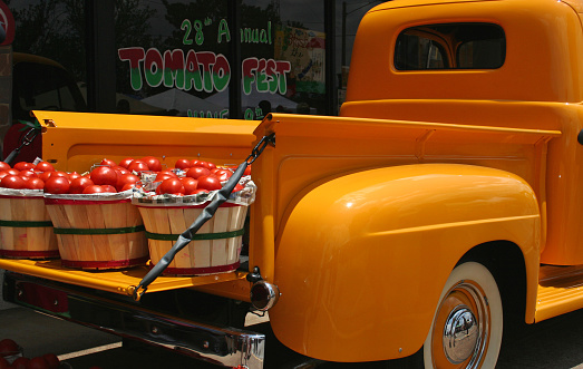 Antique Yellow Truck with baskets of Red Tomatoes