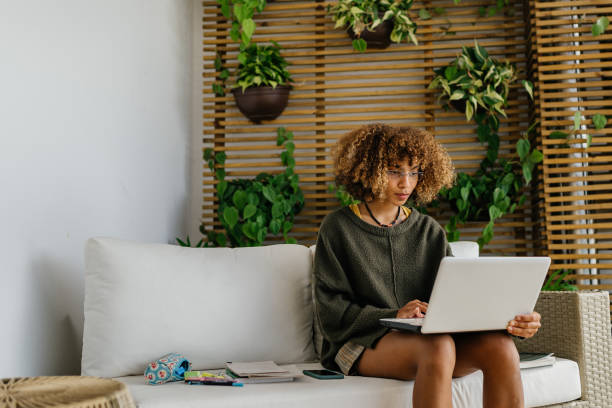 istock Young woman using laptop in sustainable house 1322426617
