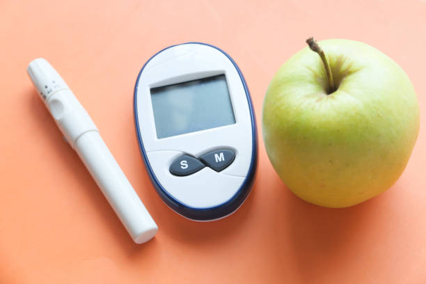 istock diabetic measurement tools, apple on orange background 1322427495