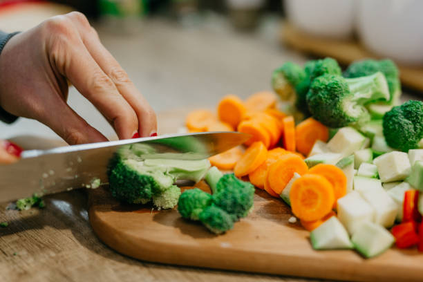 istock Hand holding a knife and cutting veggies 1322433856