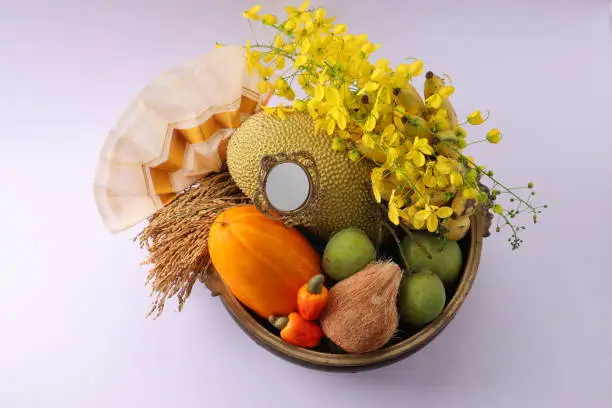 Kerala festival,rituals of Vishu festival -Vishukkani or Vishu sight, a brass vessel  or Urule filled with fruits and vegetables mostly  available in this season.mirror,golden shower flower and new cloth or kassavu mundu arranged  traditionally on white background.