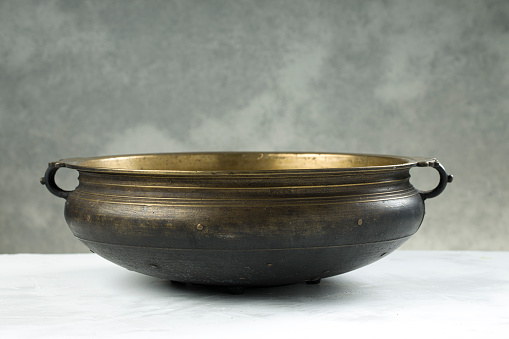 Urule or Brass vessel,an empty traditional  south Indian cooking vessel which is an antique piece placed on grey textured background.