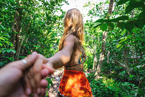 Young woman leading boyfriend to tropical rainforest-Follow me