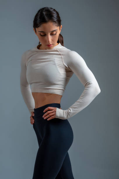 istock Athletic girl standing after workout on grey background 1322439683
