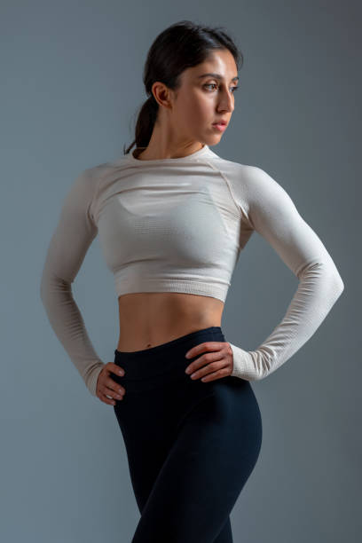istock Young sportswoman posing during workout on grey background 1322439703