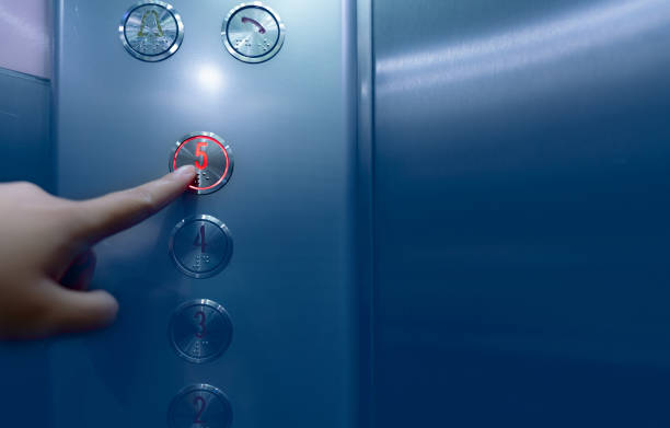 persona presionando en el quinto piso del botón del ascensor. presione con la mano el número 5 en el botón dentro del ascensor de la oficina o del hotel. pulse el dedo índice en el botón de elevación. claustrofobia. la gente se quedó atascada en el  - elevator push button stainless steel floor fotografías e imágenes de stock