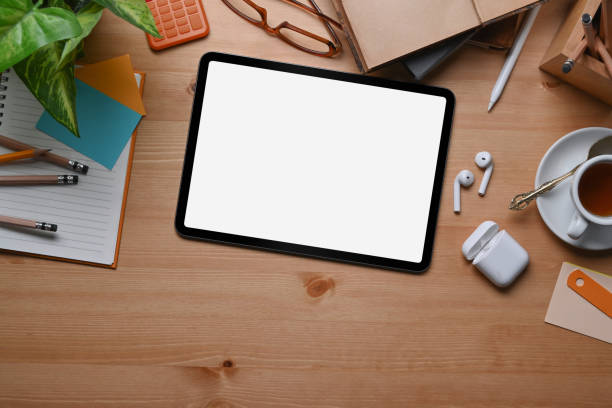 istock Mock up digital tablet with empty screen ad wireless earphone on wooden background. 1322442402