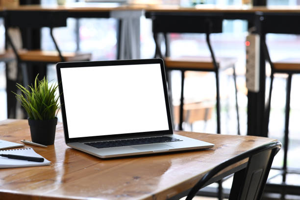 istock Mock up computer laptop with empty screen, house plant and document on wooden table. 1322442407