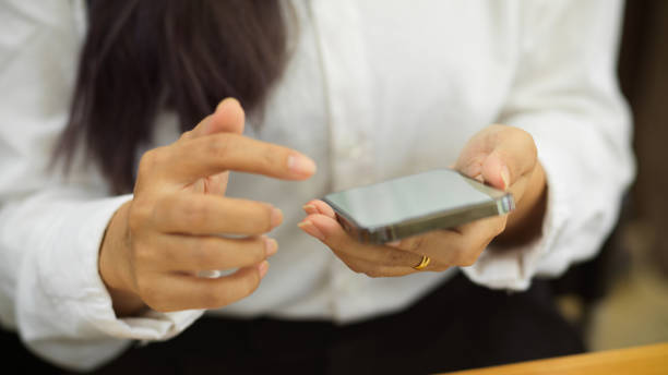 istock Cropped shot of female office worker using smartphone in her hands in workplace 1322443288