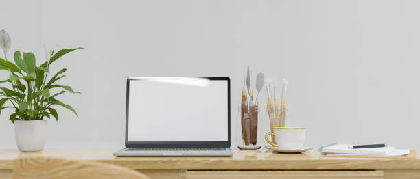 istock Working space with laptop, craft supplies, paint tools and plant pot on the table, 3D rendering 1322443910