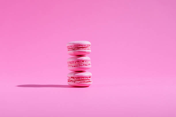 istock Three pink macaroons with pink filling stacked on pink background 1322445333