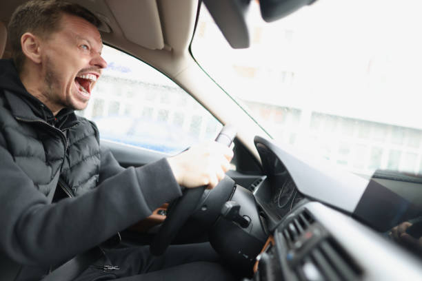 istock Angry screaming male driver driving car closeup 1322449973