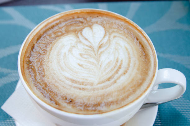 istock Coffee with foam in a cup is on the table with a brown tablecloth 1322450963