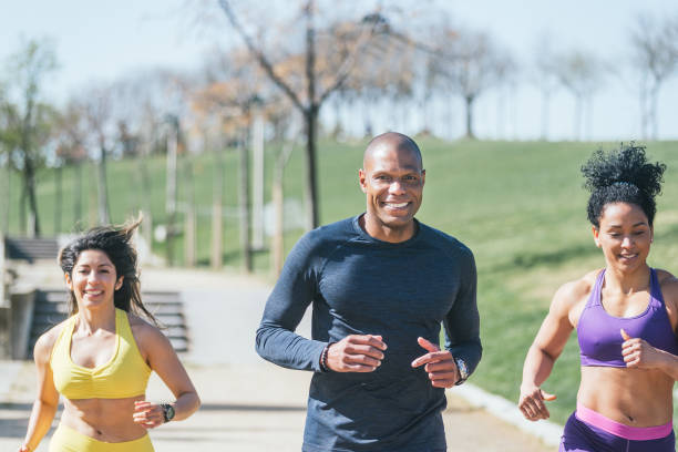 istock Two women and a man with a mask running in a park. 1322451073
