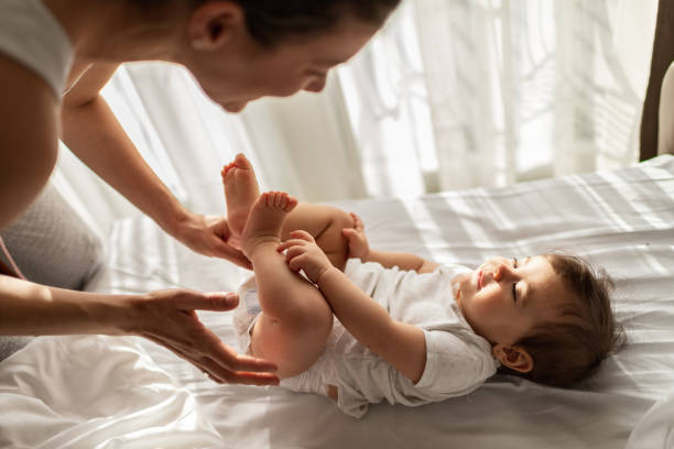 istock Mother and baby playing on bed 1322456943