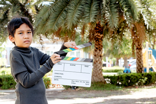 Asian boy holding film slate colors board for movie cinema and television industry