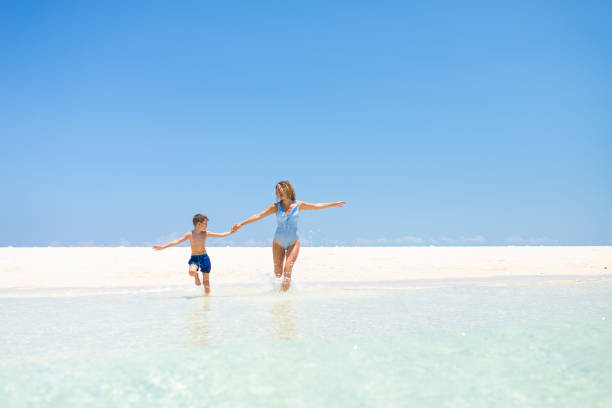 istock Happy mother and son running at the beach 1322457481