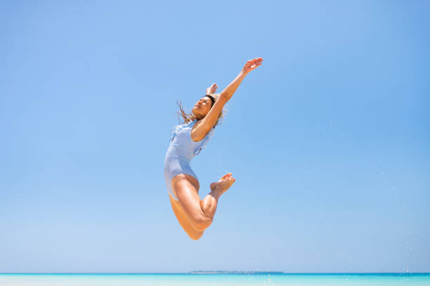 istock Happy woman jumping at the beach 1322457541
