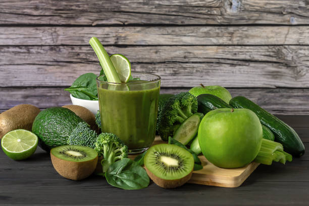 istock Fresh green vegetables and smoothie on wooden background 1322458350